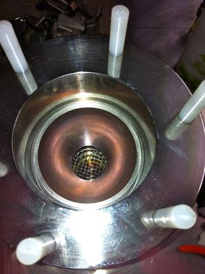 The lower half of two Tungsten hemispheres, being the reaction chamber inside the FICS cathode, note new installation of tungsten mesh over aperture. During operation the mesh gets hot and acts as a thermionic emitter, thereby maintaining a degree of ionization in the beam line, which in turn fuels the secondary ionization inside the cathode.
