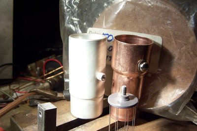 Feed though protection shields, old and new.  The new one is anodized aluminum, and a lot slicker generally (and lower sputtering) than the copper prototype.  This can be used as a faraday probe or antenna for driving fields as well.